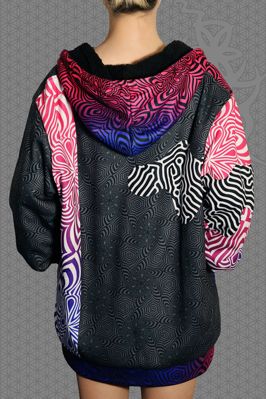 back view psychedelic rave zip hoodie with neon pink, purple, and blue geometric optical patterns and black panel design with black fleece interior lining