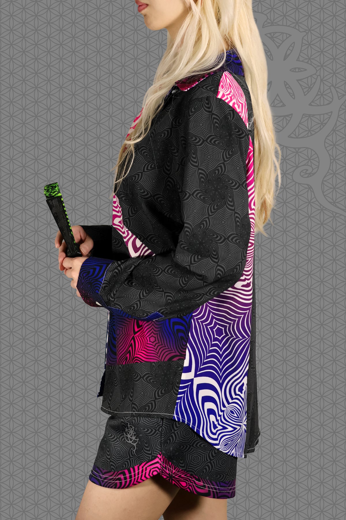 left view psychedelic rave women button up shirt with neon pink, purple, and blue geometric optical patterns and gradient panels