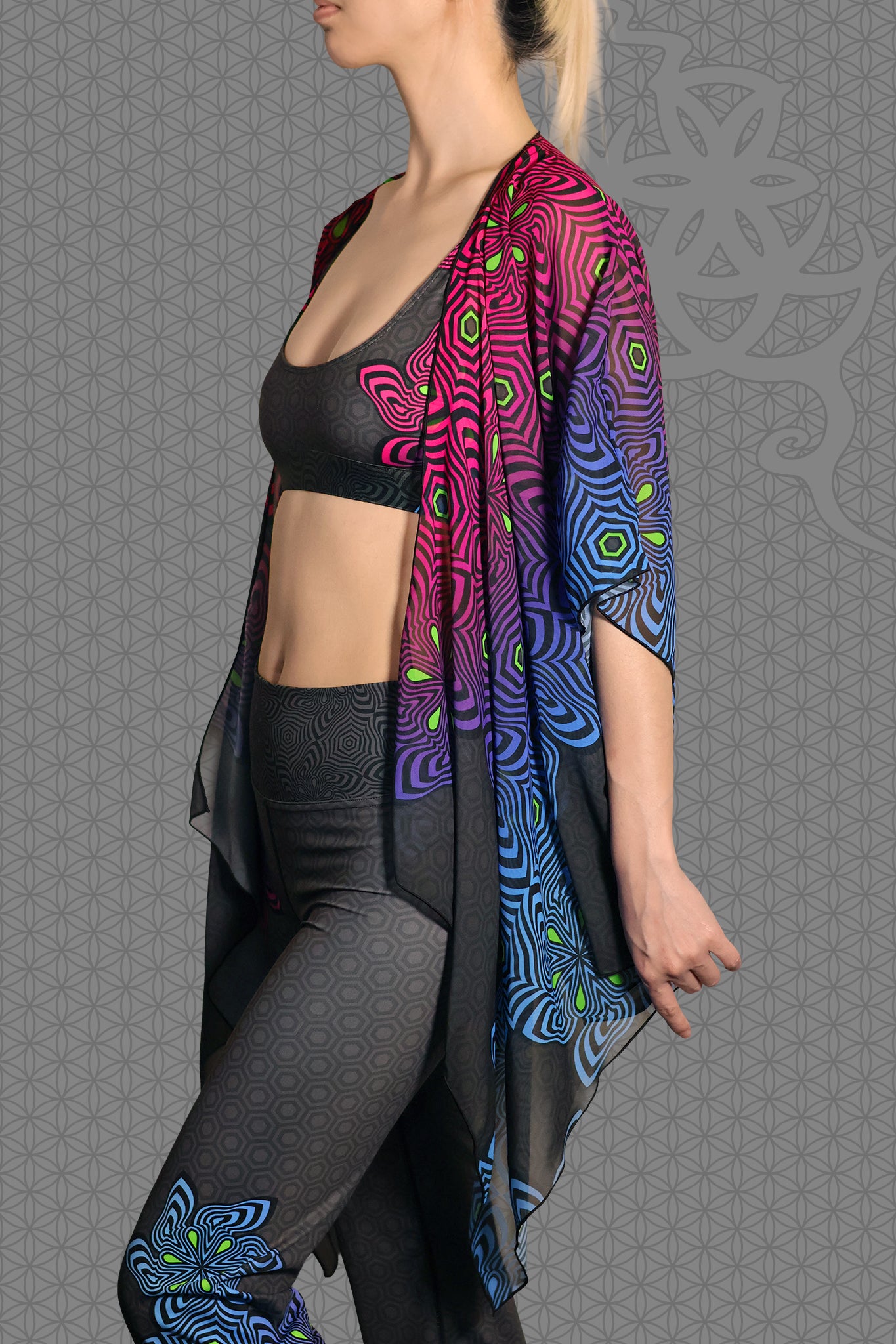 left view sheer chiffon psychedelic rave kimono with neon pink, purple, blue, and green geometric optical patterns on black