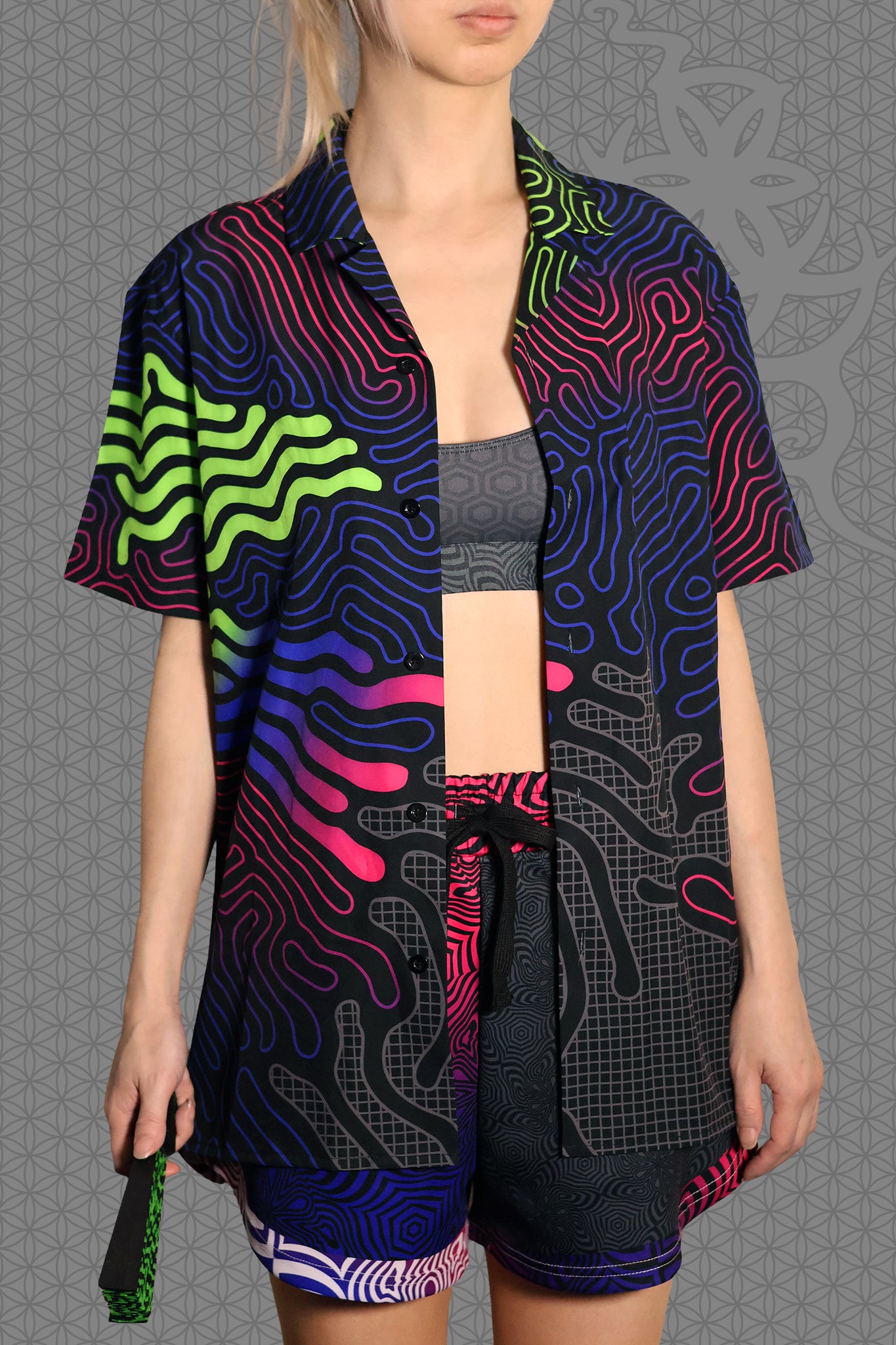 front view psychedelic short sleeve camp shirt with black base and flowing neon reaction diffusion patterns in green, pink, blue, and purple, featuring button front and spread collar