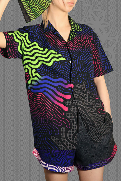 model view psychedelic short sleeve camp shirt with black base and flowing neon reaction diffusion patterns in green, pink, blue, and purple, featuring button front and spread collar