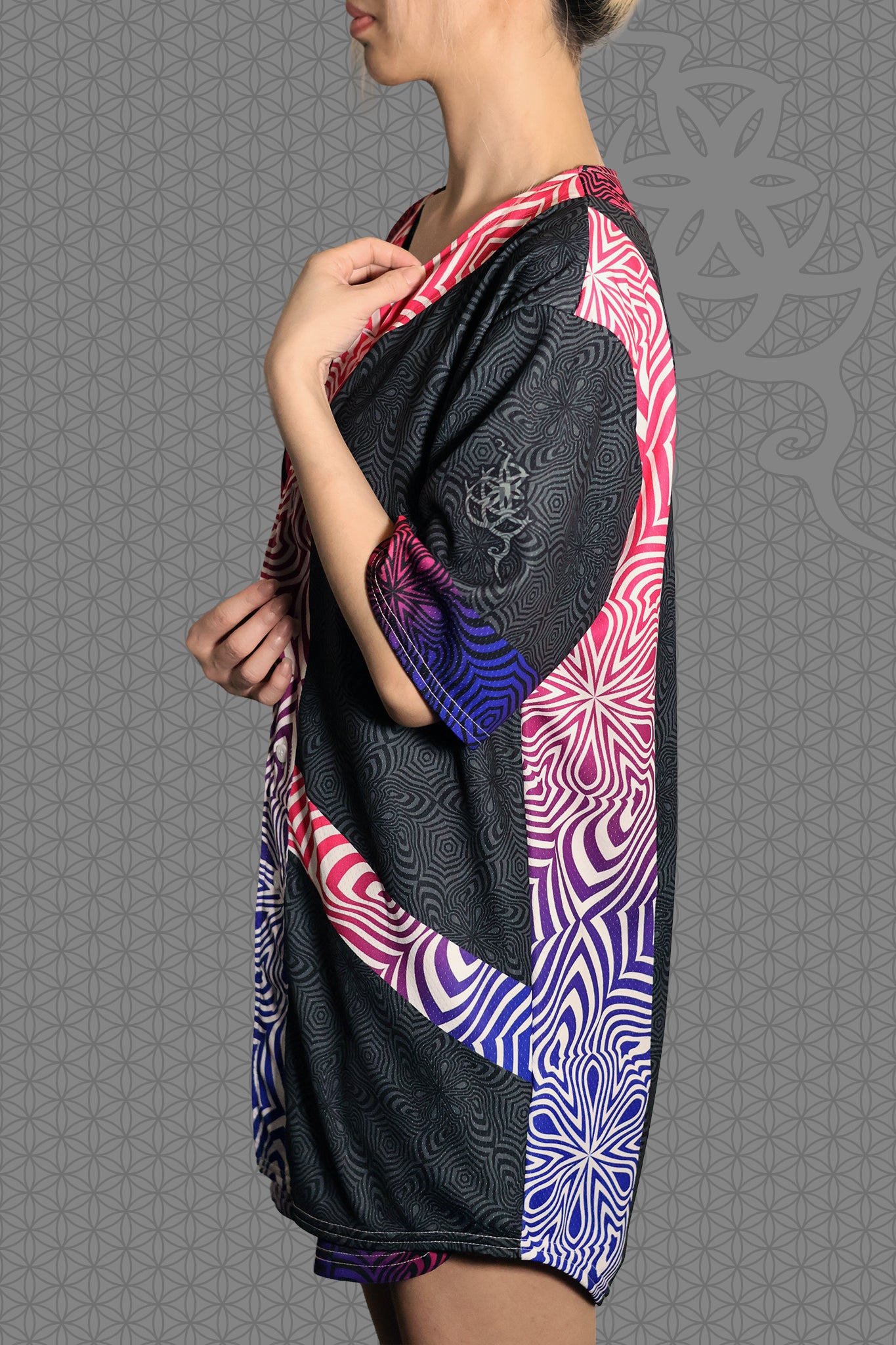 left view psychedelic rave baseball jersey with neon pink, purple, and blue geometric optical patterns and gradient panels