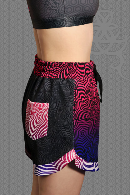 right view psychedelic loose-fit shorts with black geometric pattern body, magenta-to-purple optical pattern panels and waistband, gradient pink-purple-blue accents, drawstring waist, and contrasting patterned back pocket