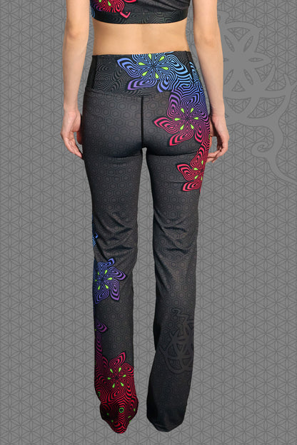 back view psychedelic rave flare leggings with neon pink, purple, blue, and green flower patterns on black