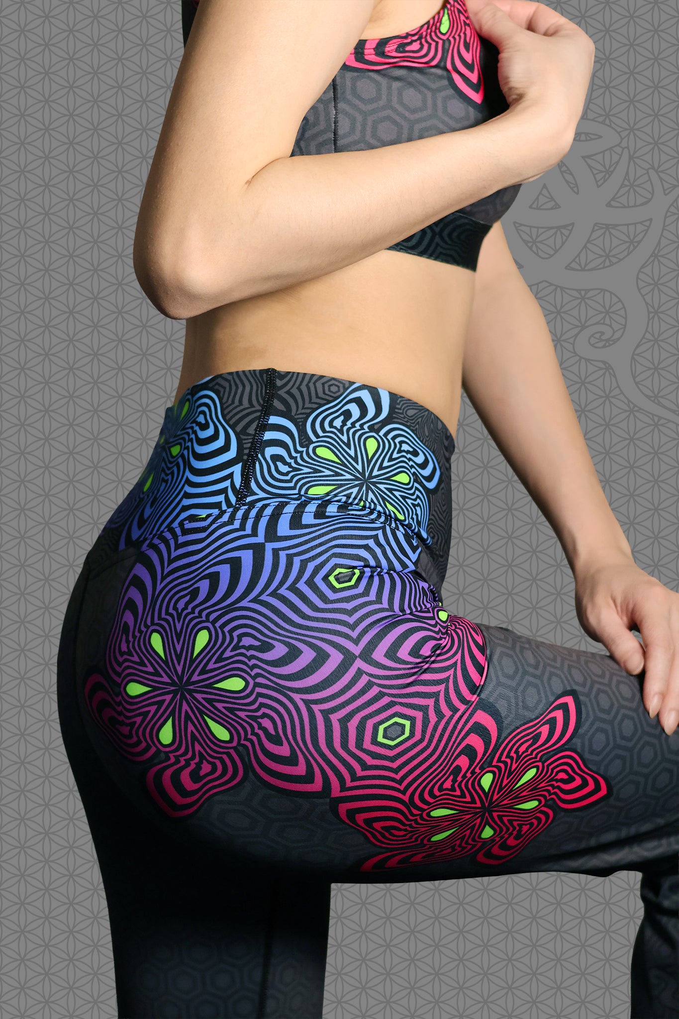 close-up view psychedelic rave flare leggings with neon pink, purple, blue, and green flower patterns on black